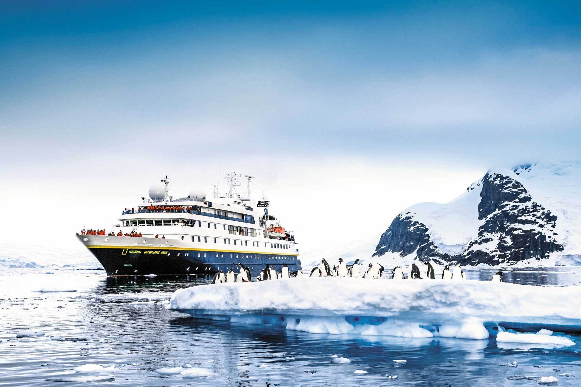 Guests from the bow of the National Geographic Orion look at a small colony of penguins on an ice floe.