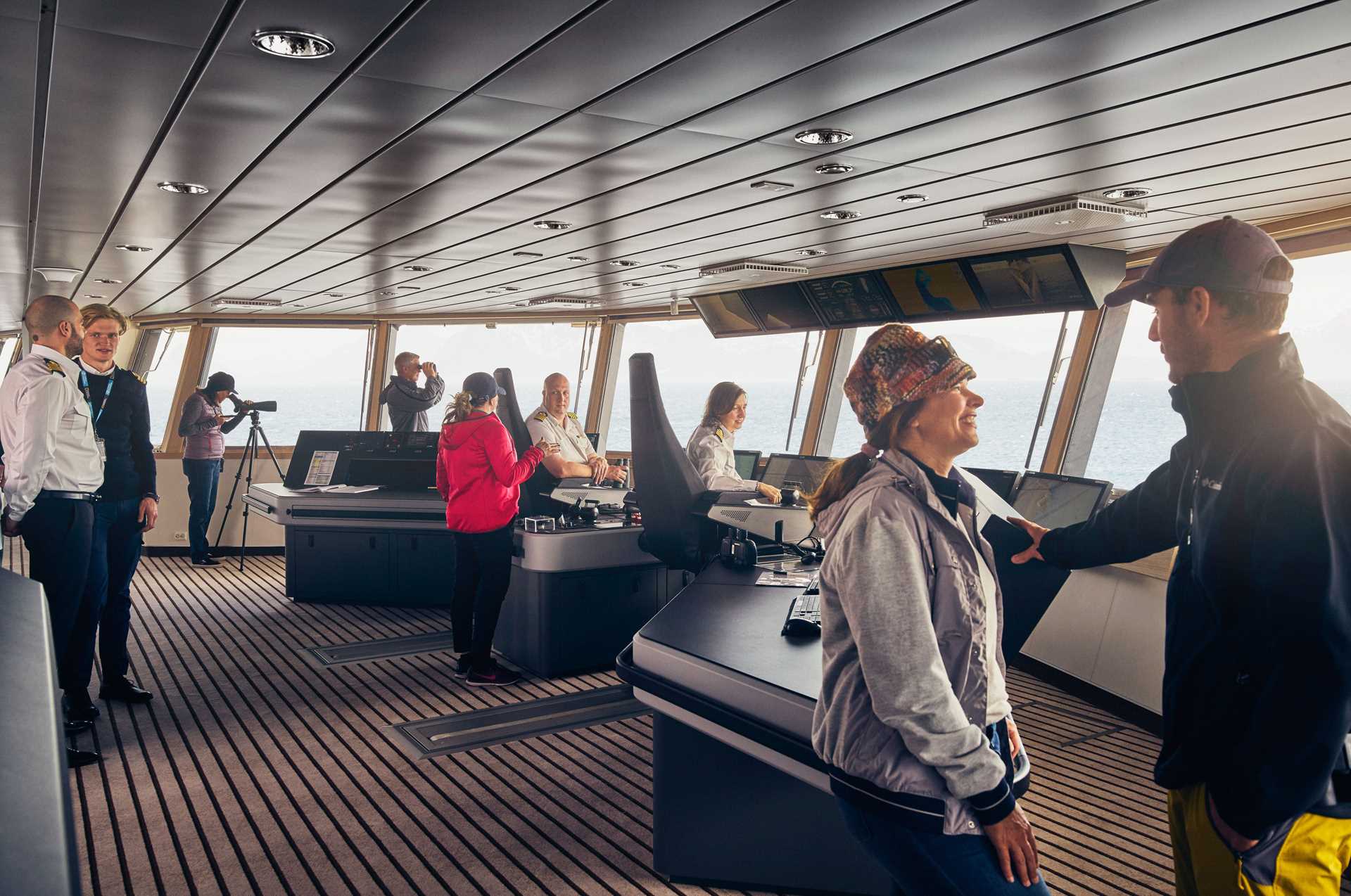 Guests talk to crew members of the National Geographic Endurance on the ship's bridge.