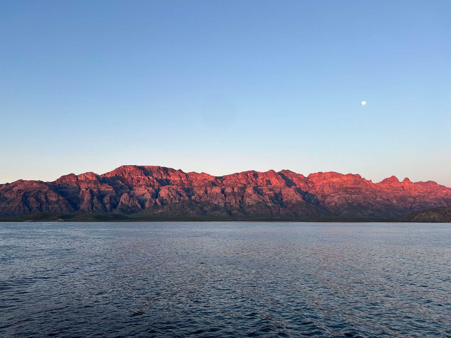 red mountains and water at sunset