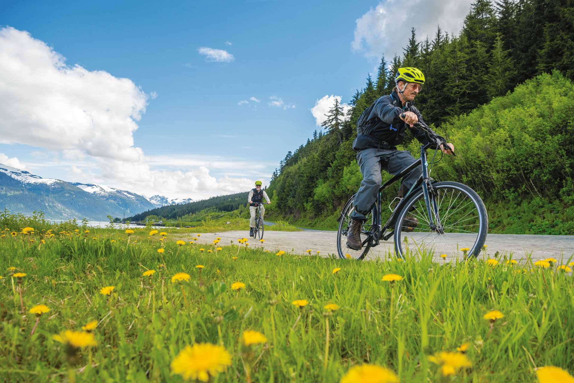 Guests enjoy a scenic bicycle ride along a glacial fjord to salmon spawning grounds overlooking an emerald lake in Haines, Alaska.