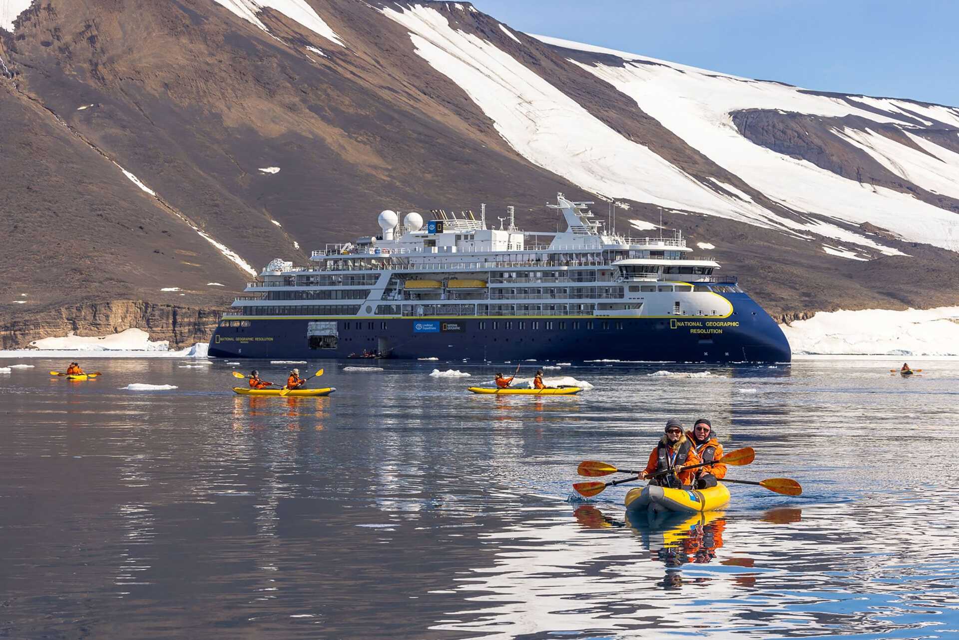 people paddle kayaks in front of the National Geographic Resolution